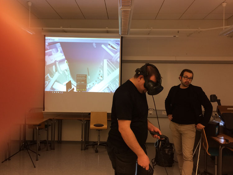 Tutkimusinsinööri Marko Pekkarinen tutkii Energiatutkimuskeskuksen VR-mallia yhdessä Sweco Oy:n Jarkko Heikuran kanssa.